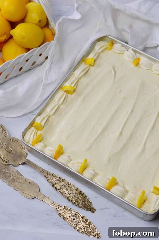 rectangle pan of lemon cheesecake cake with silver servers