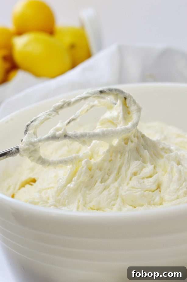 beater and white bowl of lemon buttercream frosting