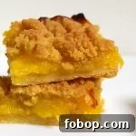 Lemon Curd Shortbread Crumble Bars 9 Lemon curd crumble slice on white background.