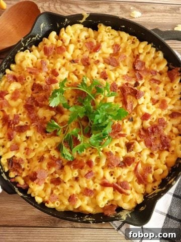 mac and cheese in cast iron skillet with spoon