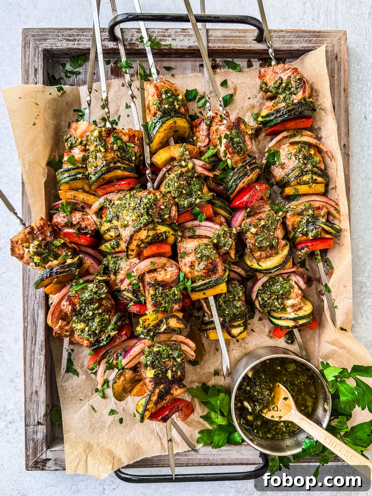 Salmon kebabs slathered in chimichurri on a serving platter.