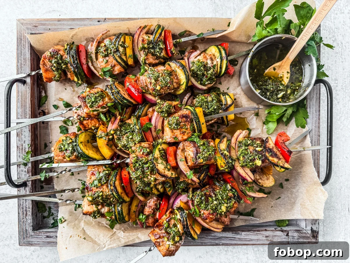Salmon kebabs slathered in chimichurri on a serving platter.