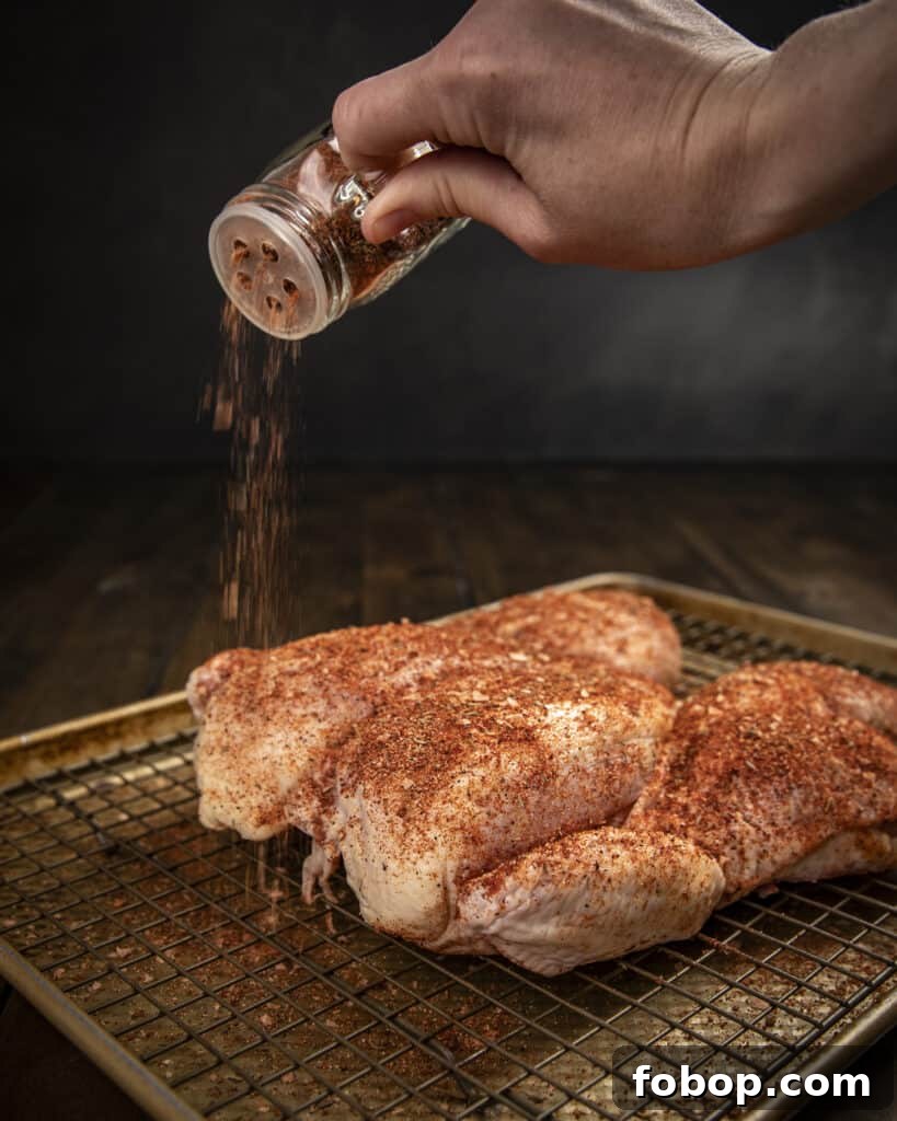 Smoked Chicken Dry Rub Recipe for Juicy, Flavor-Packed Results 3 Sprinkling chicken rub on a whole chicken