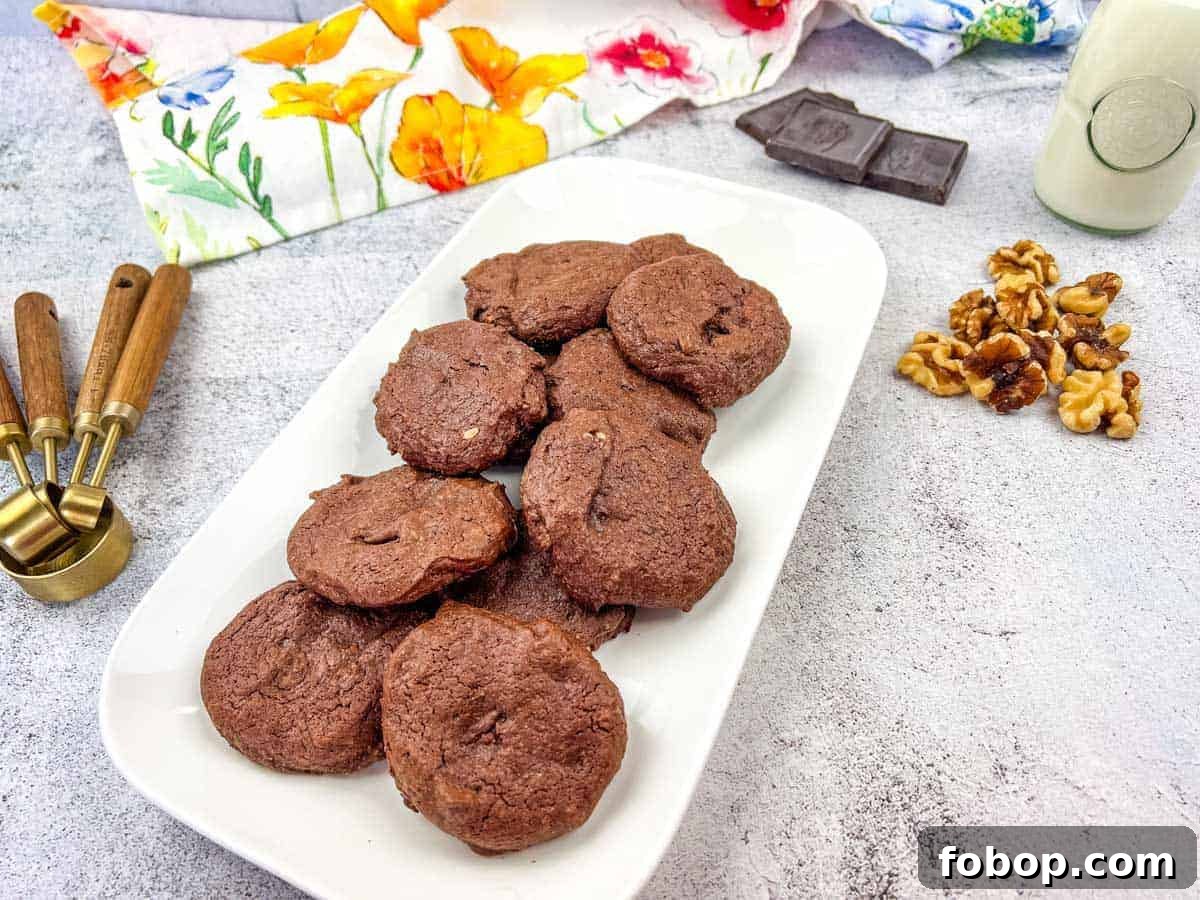 25 Office Cookies Everyone Brings and Raves About 13 A plate of chocolate cookies with walnuts and chocolate pieces on the side.
