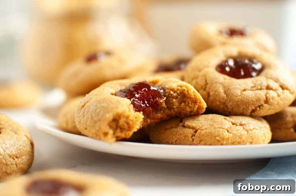 25 Office Cookies Everyone Brings and Raves About 23 A close-up of peanut butter thumbprint cookies filled with red jelly.