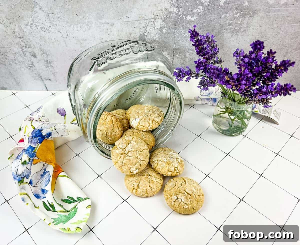 25 Office Cookies Everyone Brings and Raves About 24 A jar of White Chocolate Crinkle Cookies next to lavender flowers.