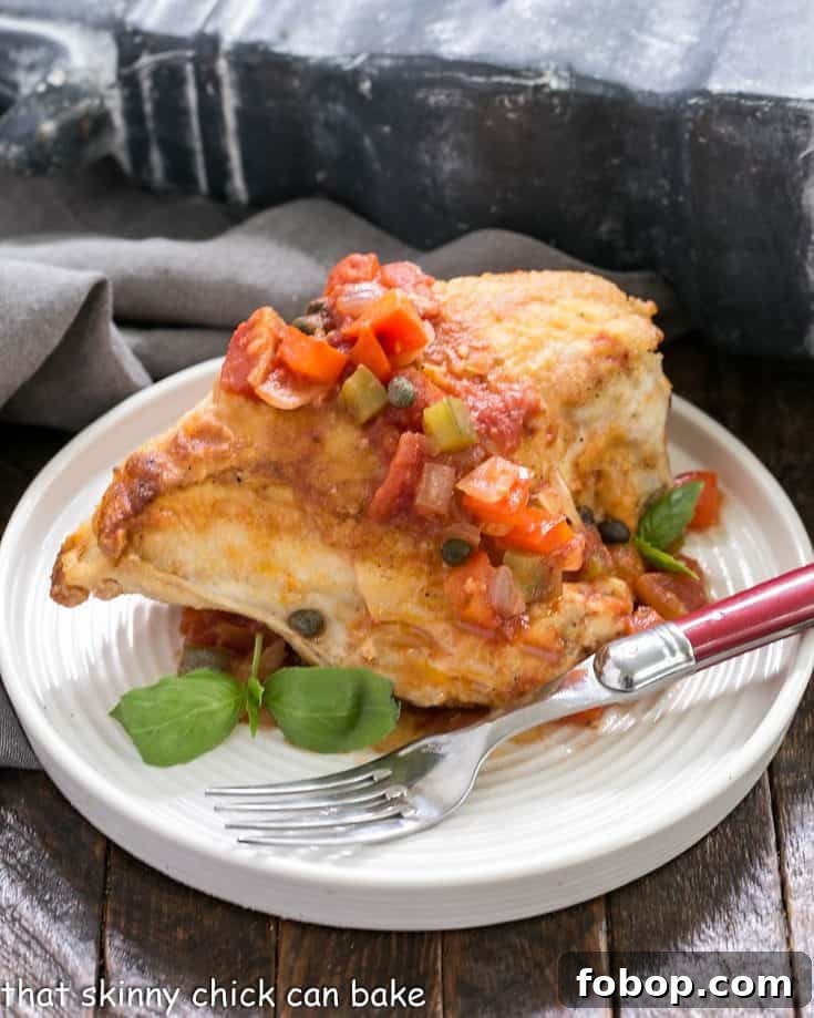 Chicken Cacciatore on a white plate with a red handle fork.