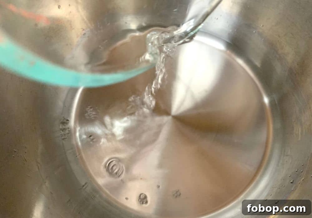 Instant Pot Frozen Dumplings (Potstickers) in Minutes 5 A glass measuring cup pouring water into the insert pot of the Instant Pot.