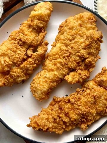 overhead shot of cooked chicken strips on plate with side of gravy