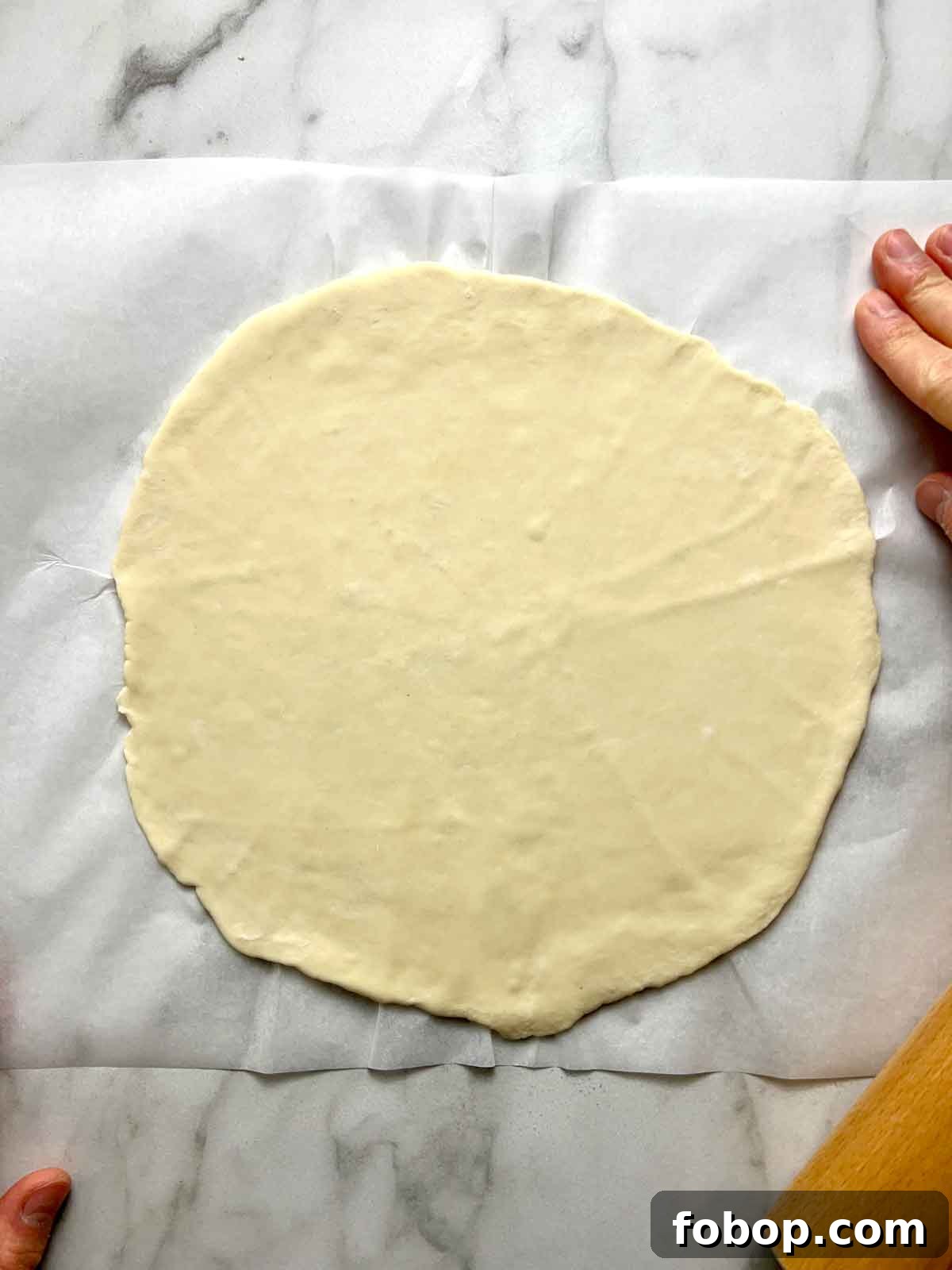 Crispy Cracker-Crust Pizza Recipe: Thin, Crunchy Homemade Pie 7 dough flattened into thin round on parchment paper