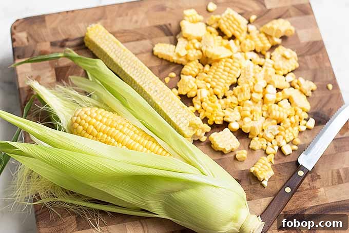 Summer Corn Chowder with Garlic Herb Bread: Creamy Seasonal Recipe 5 Cutting kernels from fresh corn for our creamy chowder recipe.
