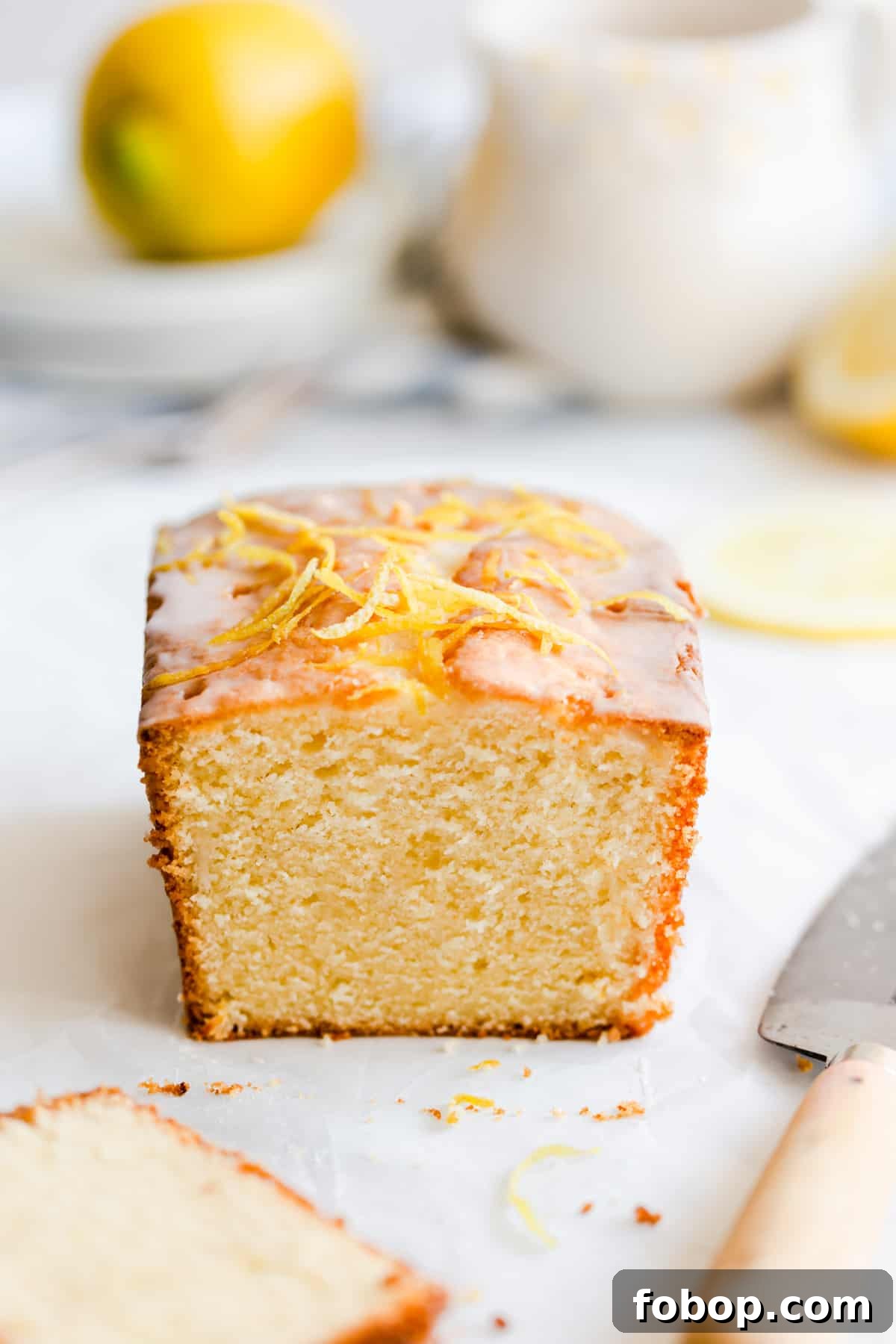 straight ahead shot of lemon drizzle cake with slice cut off