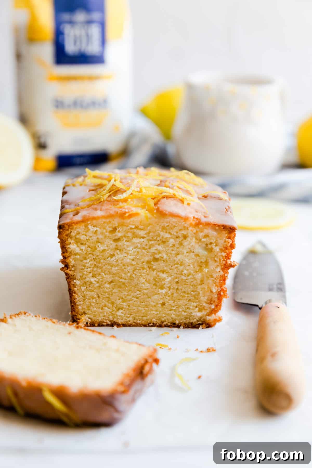 side close up at small batch lemon drizzle cake with a slice cut off