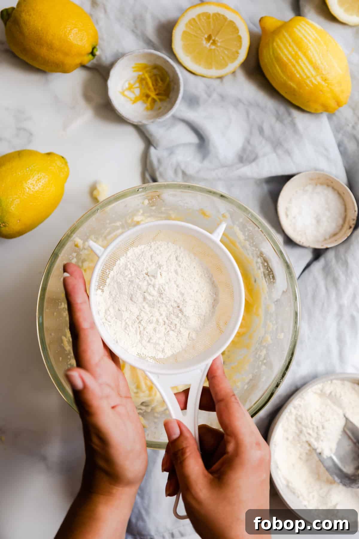 overhead shot of a person sieving the flour into a bowl