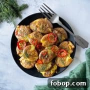 Smashed air fryer potatoes dressed in lemon, rosemary, chili vinaigrette on a black plate.