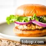 A closeup side view is shown of an air fryer turkey burger on a light blue plate.