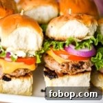 A closeup shot of turkey burger sliders on a white platter.