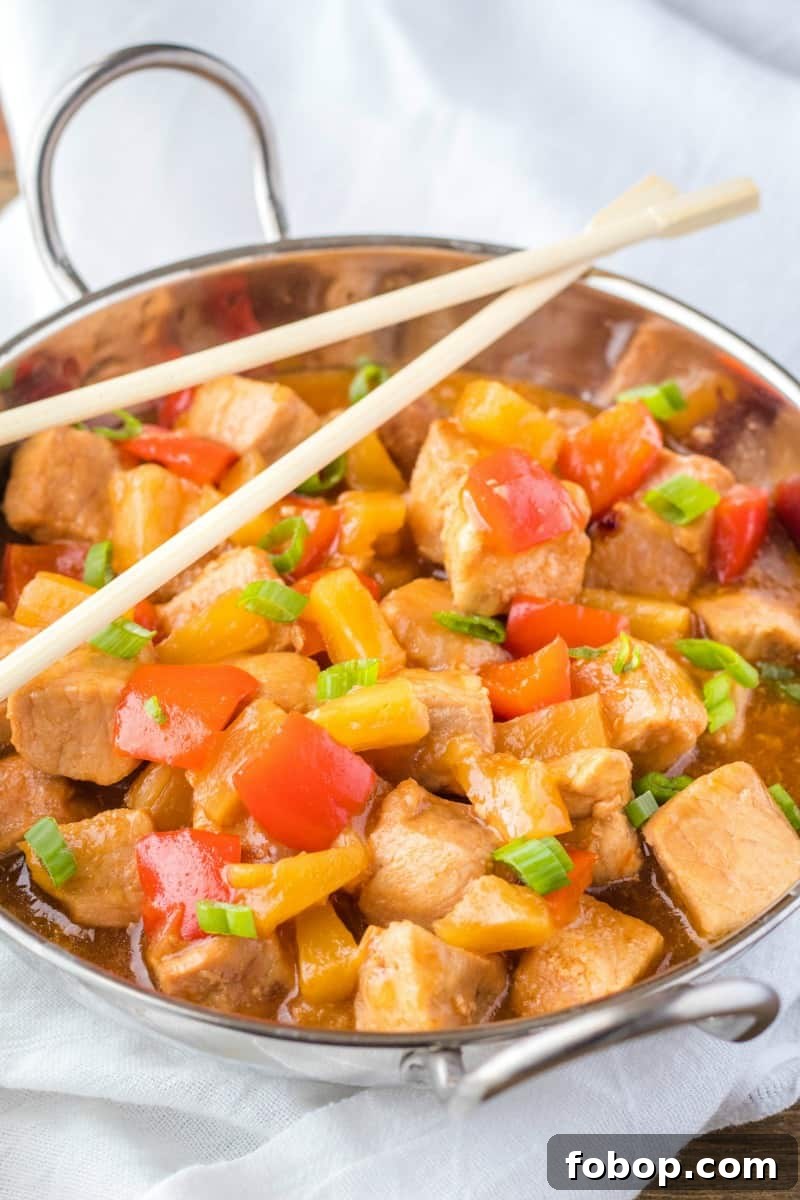 Slow Cooker Sweet and Sour Pork Recipe for Tender, Saucy Pork 5 sweet & sour pork in a serving bowl topped with green onion