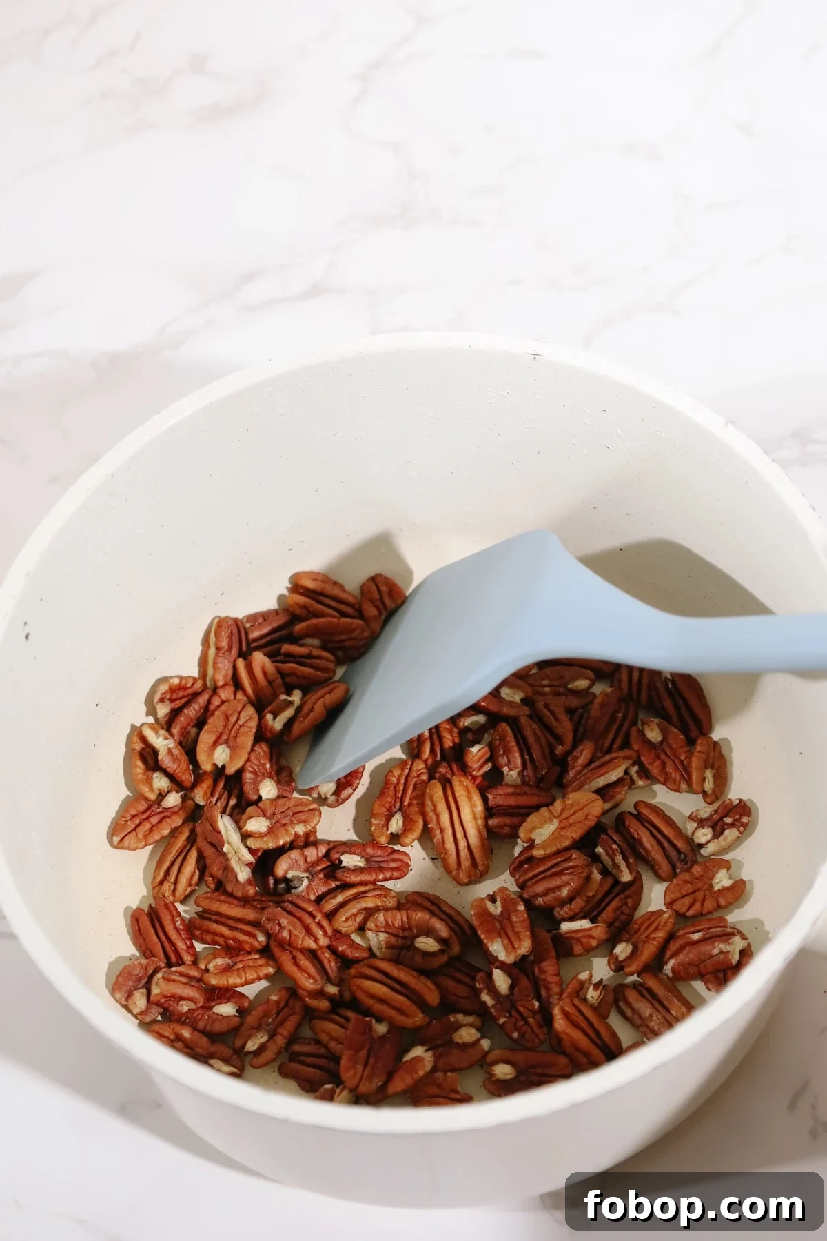Step one: warm pecans in a skillet.