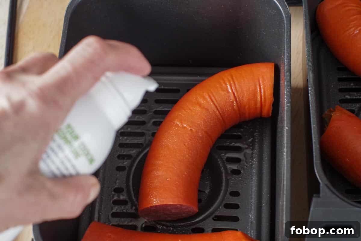 kielbasa being sprayed with a few pumps of oil
