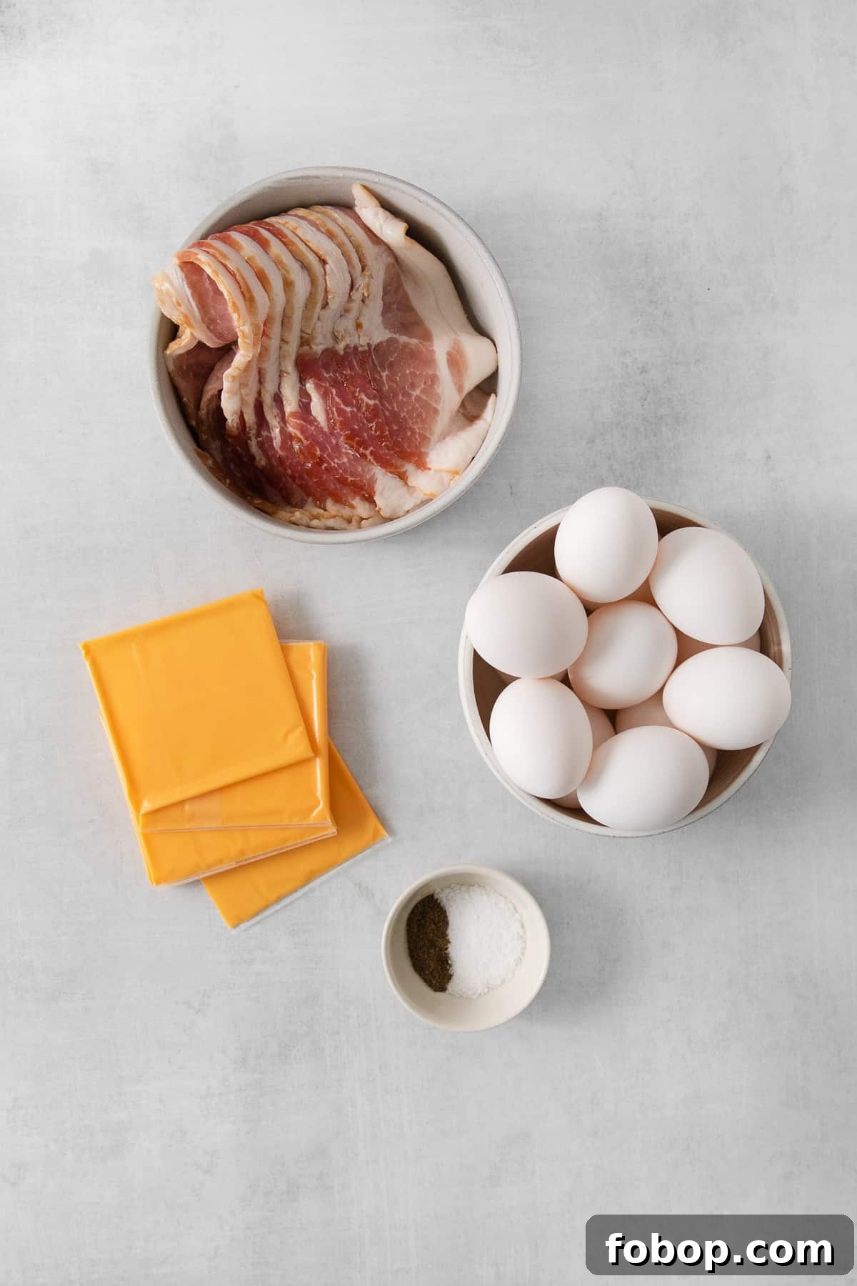 How to Make a Copycat Bacon Egg and Cheese Sandwich Recipe 4 eggs, bacon, cheese and other ingredients on a table.