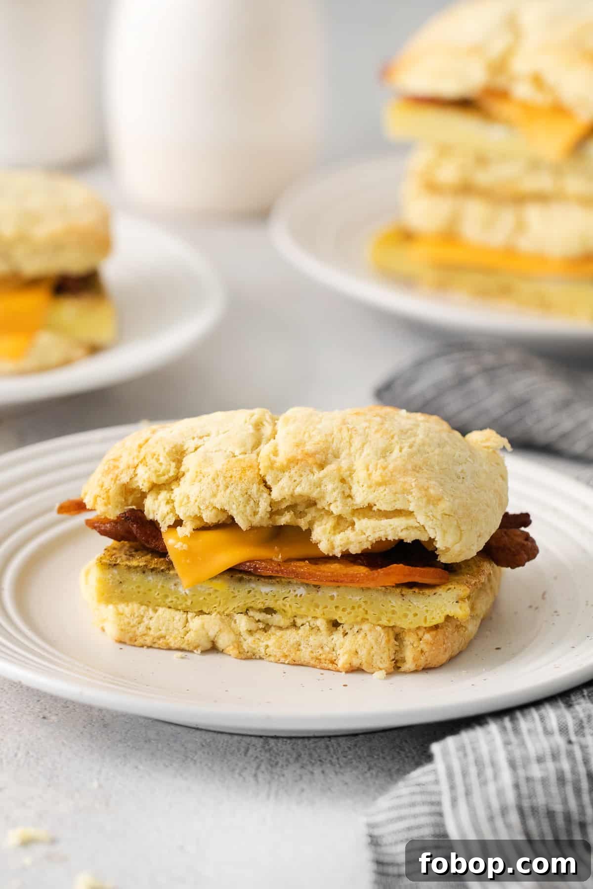 How to Make a Copycat Bacon Egg and Cheese Sandwich Recipe 9 a stack of biscuits with bacon and cheese on a plate.