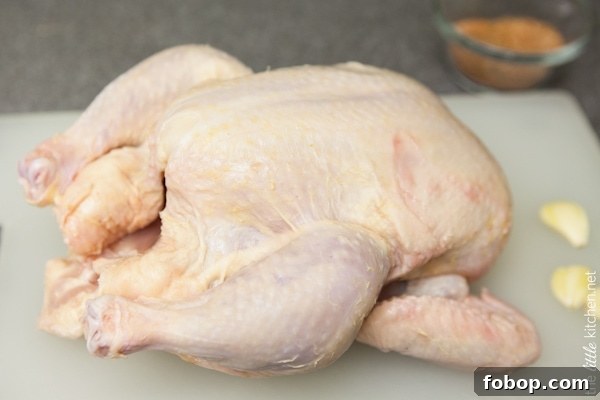 Crockpot Whole Chicken from TheLittleKitchen.net whole chicken on a cutting board with garlic