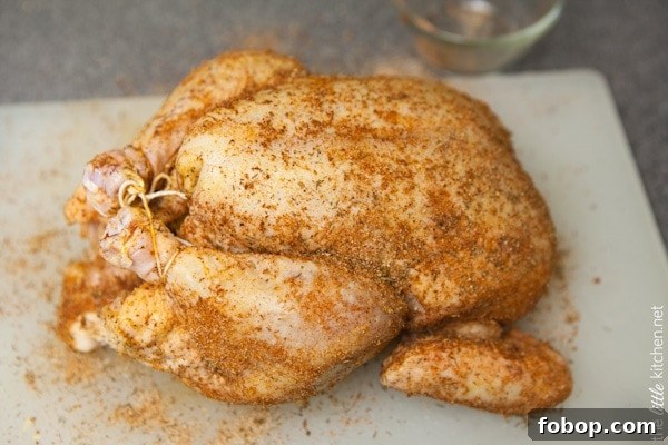 Whole Chicken in a Slow Cooker from TheLittleKitchen.net whole chicken tied with kitchen twine on a cutting board