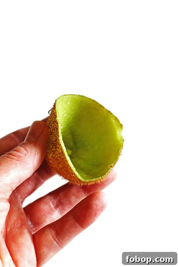 Hand holding the skin of a kiwi