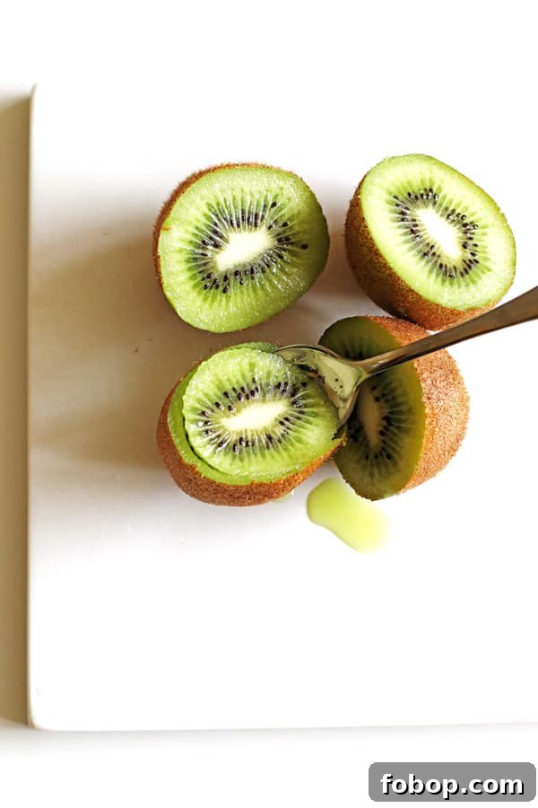 Scooping out the green kiwi using a spoon