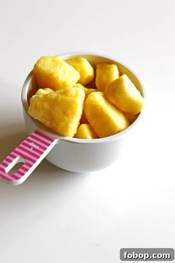 Frozen pineapple in a white measuring cup