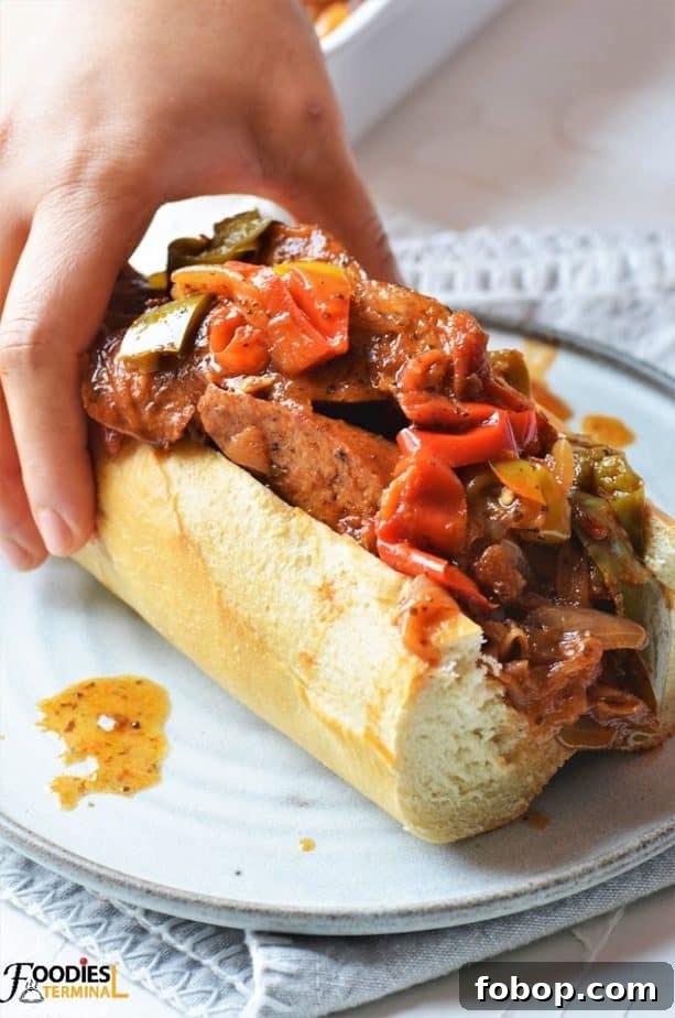 Instant Pot Sausage with Peppers and Onion Dinner 4 Sausage and Pepper Sandwich in a baguette on a grey plate