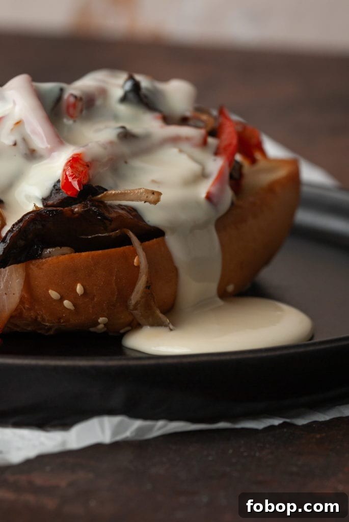 closeup of cheese sauce dripping out of portobello cheesesteak