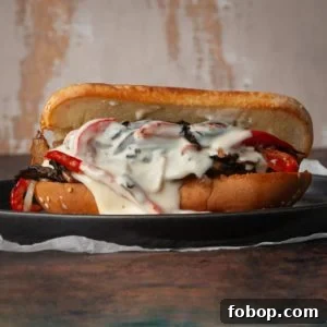 vegetarian philly cheesesteak with cheese sauce oozing out on hoagie roll