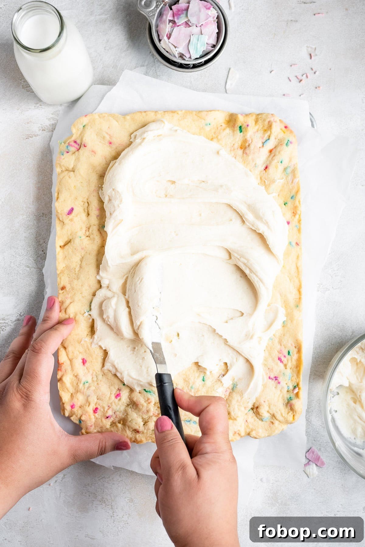 spreading frosting on sugar cookie bars