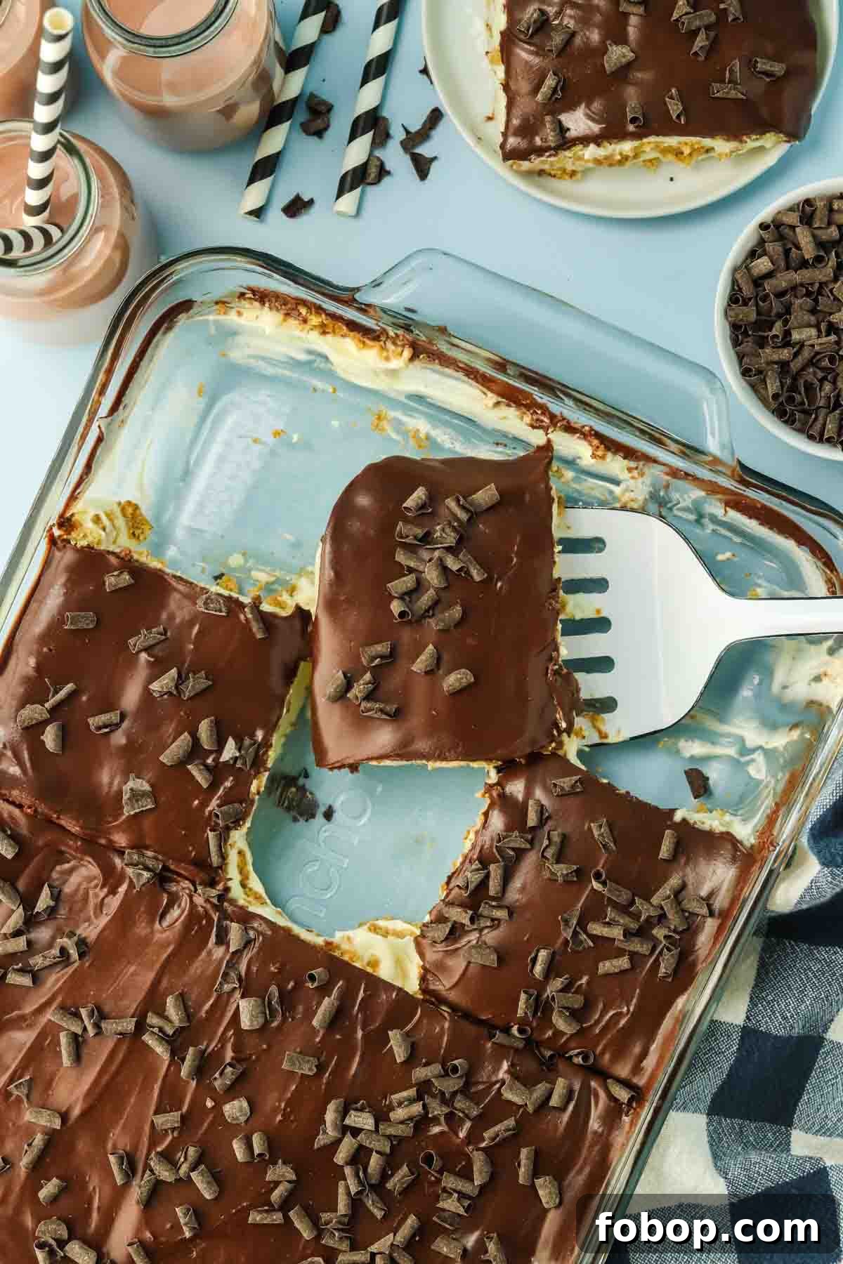 No-Bake Chocolate Eclair Cake Recipe (No Oven Needed) 12 9x13 pan of chocolate eclair cake cut into squares ready to serve - Hostess At Heart