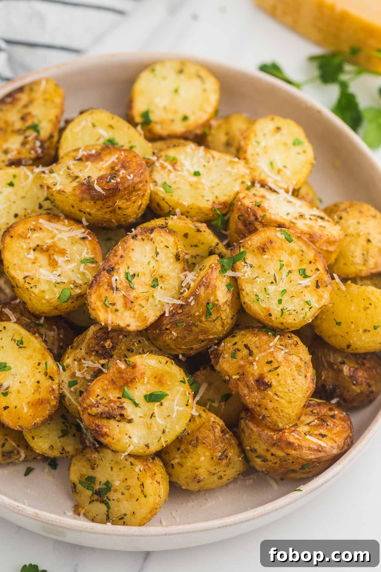 Crispy Air Fryer Roasted Potatoes with Garlic and Herbs 2 Perfectly golden roasted baby potatoes served on a plate