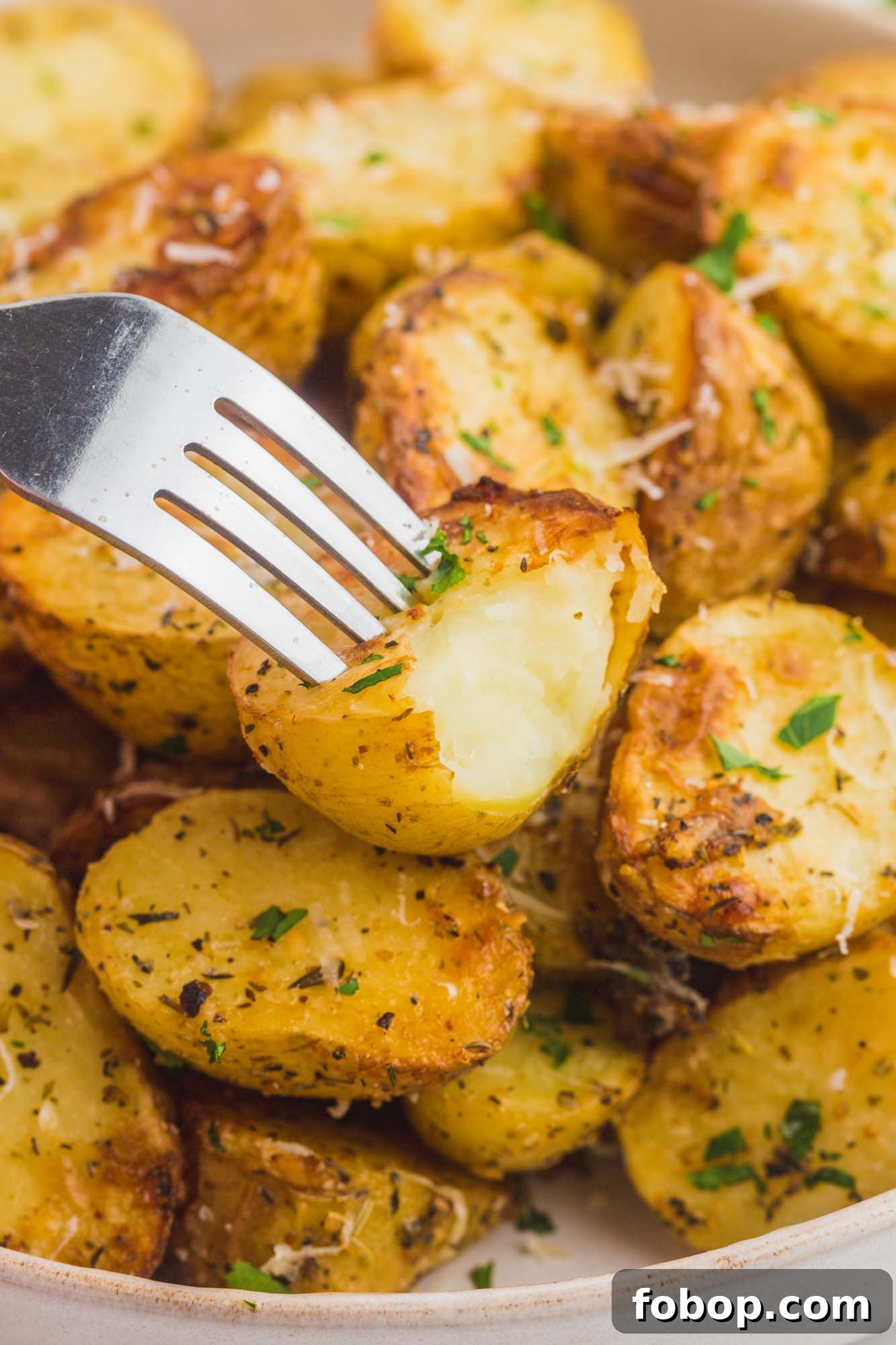 Crispy Air Fryer Roasted Potatoes with Garlic and Herbs 6 A bite shot of roasted potatoes with a fork