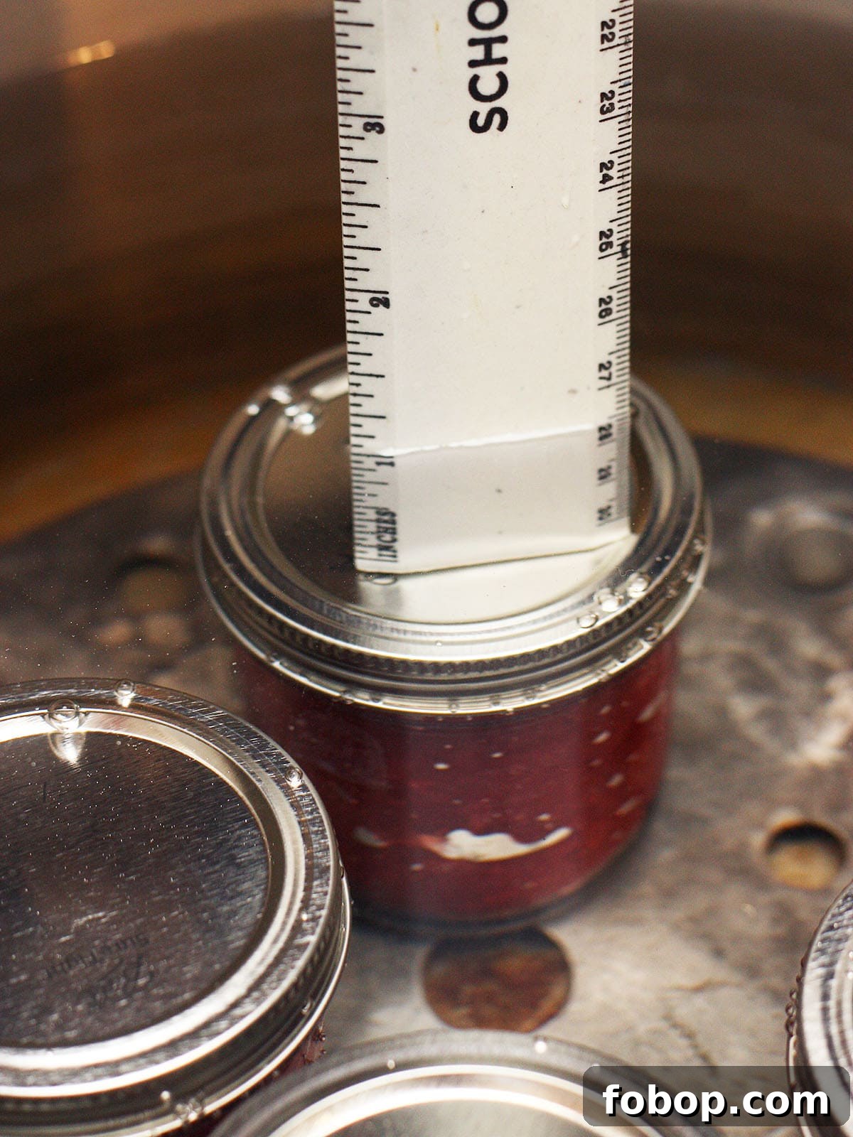 ruler showing the water level over the tops of the jars