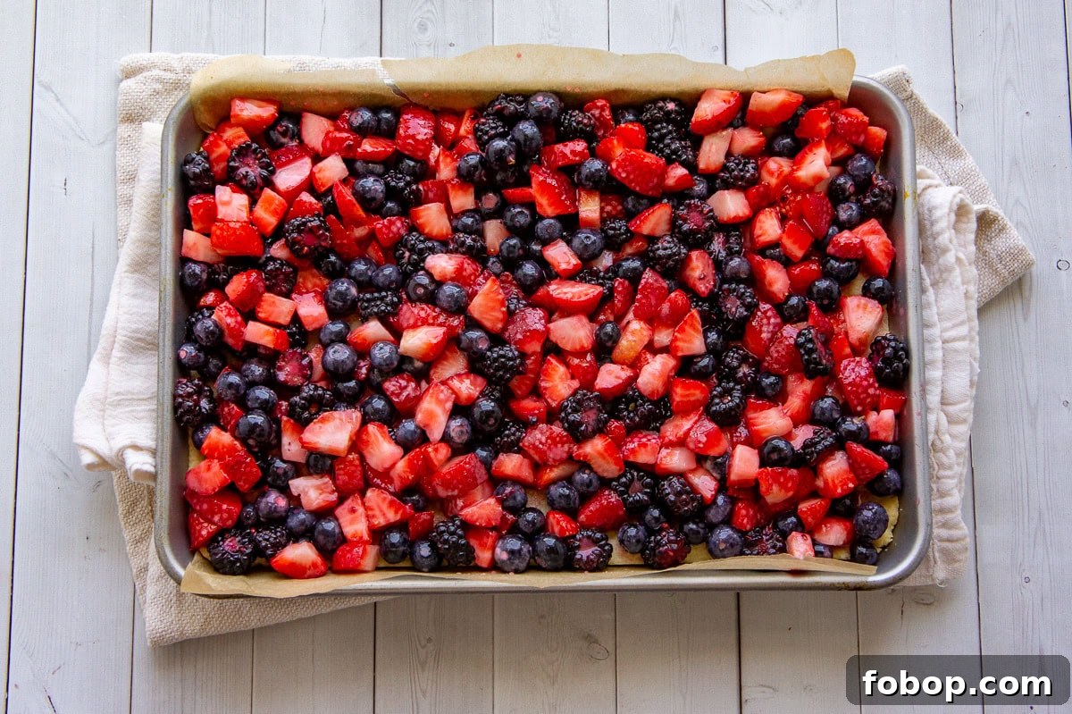 a sheet pan with mixed berries spread across it.