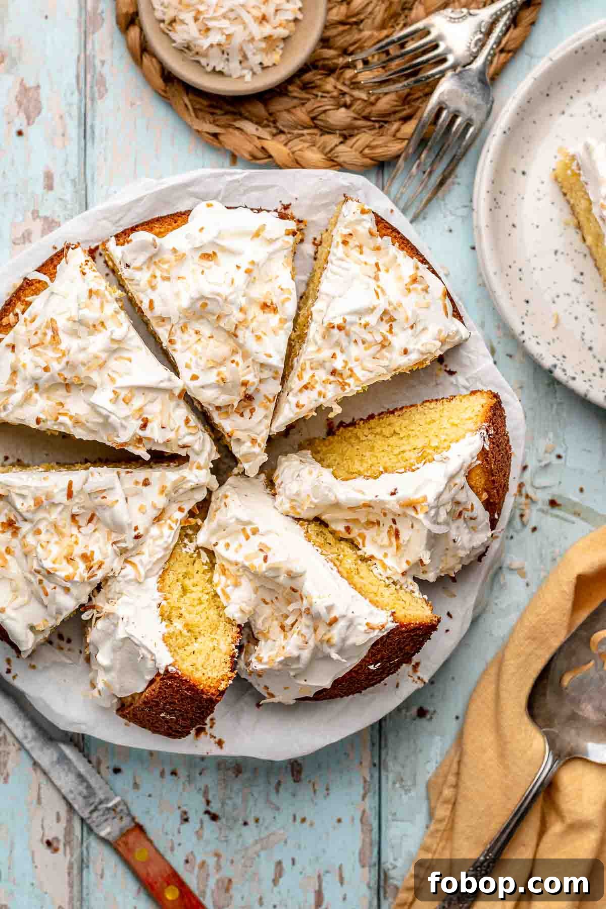 Coconut Almond Cake Recipe with Moist Layers and Toasted Almonds 11 Sliced coconut almond cake on a platter.