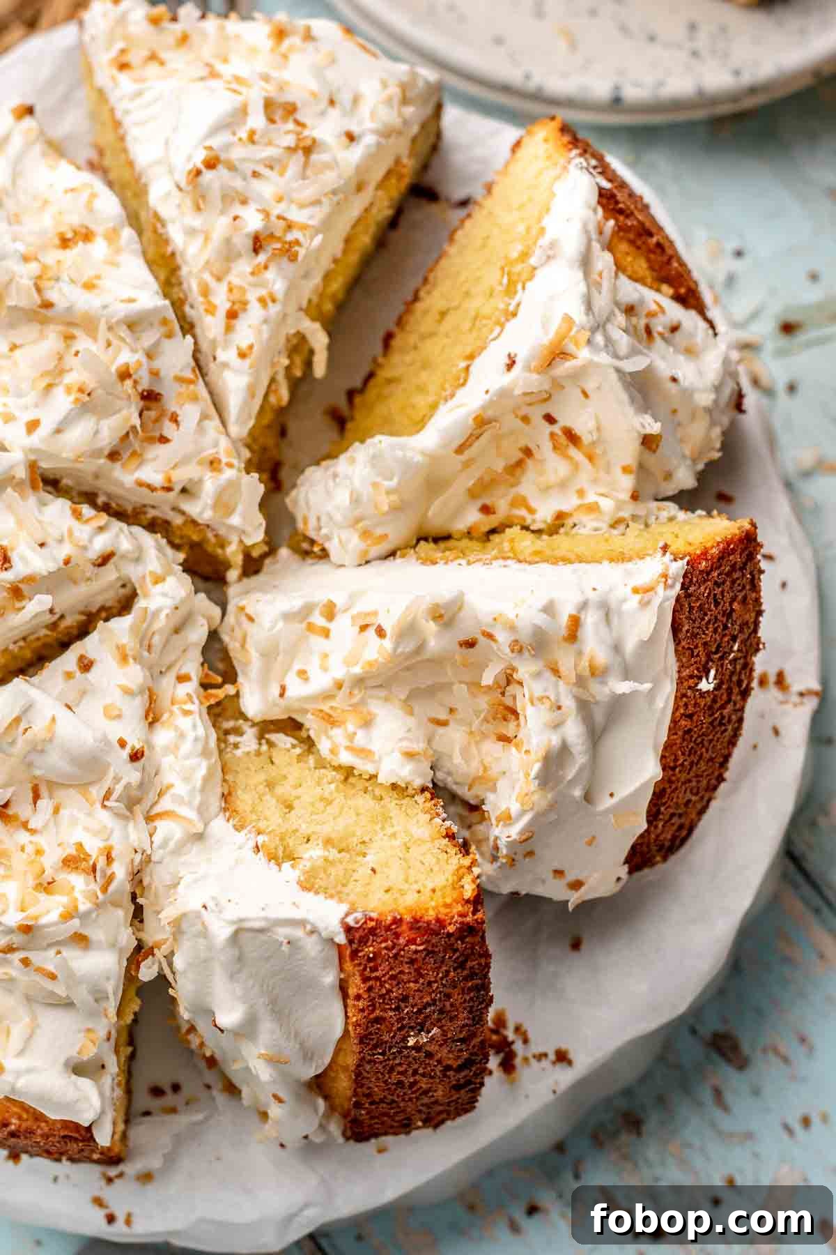 Coconut Almond Cake Recipe with Moist Layers and Toasted Almonds 4 Sliced coconut almond cake on a platter.