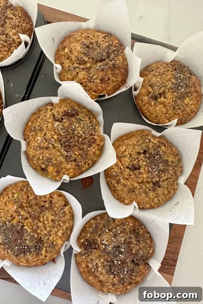 Sourdough Morning Glory Muffins in paper liners sitting in a 6 hole muffin tray.