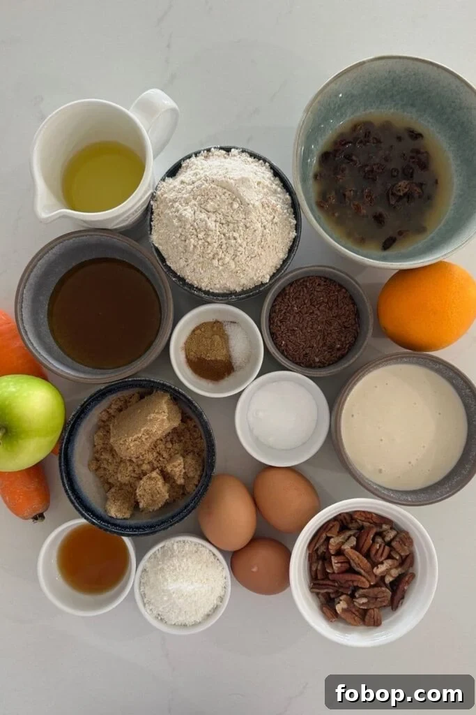 All of the ingredients used to make sourdough morning glory muffins including whole wheat flour, carrot, apple, pecans, eggs, seeds, orange, brown sugar.