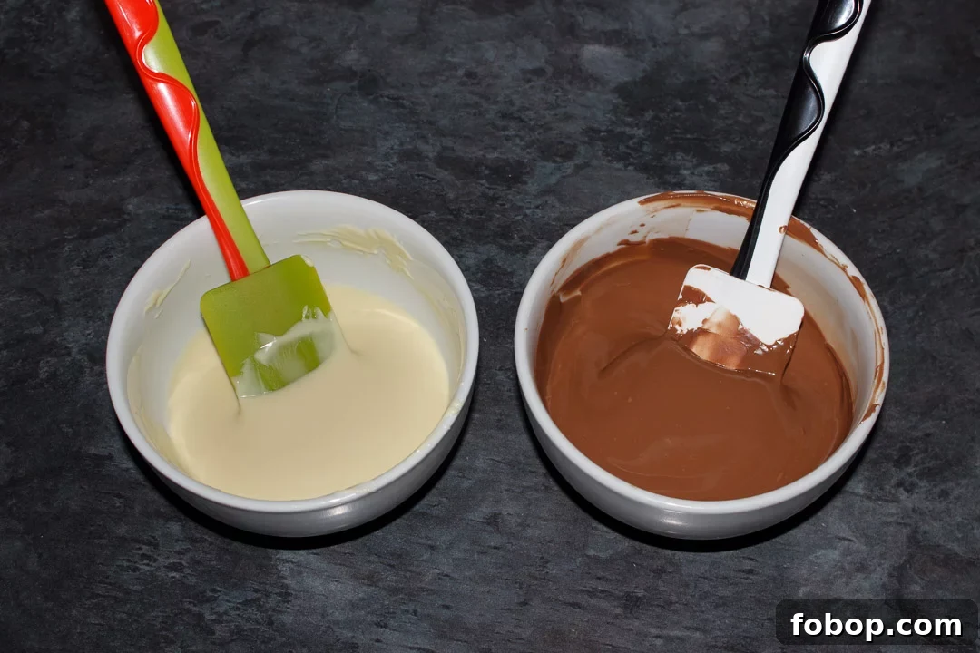 Two bowls, one with melted white chocolate and the other with melted milk chocolate