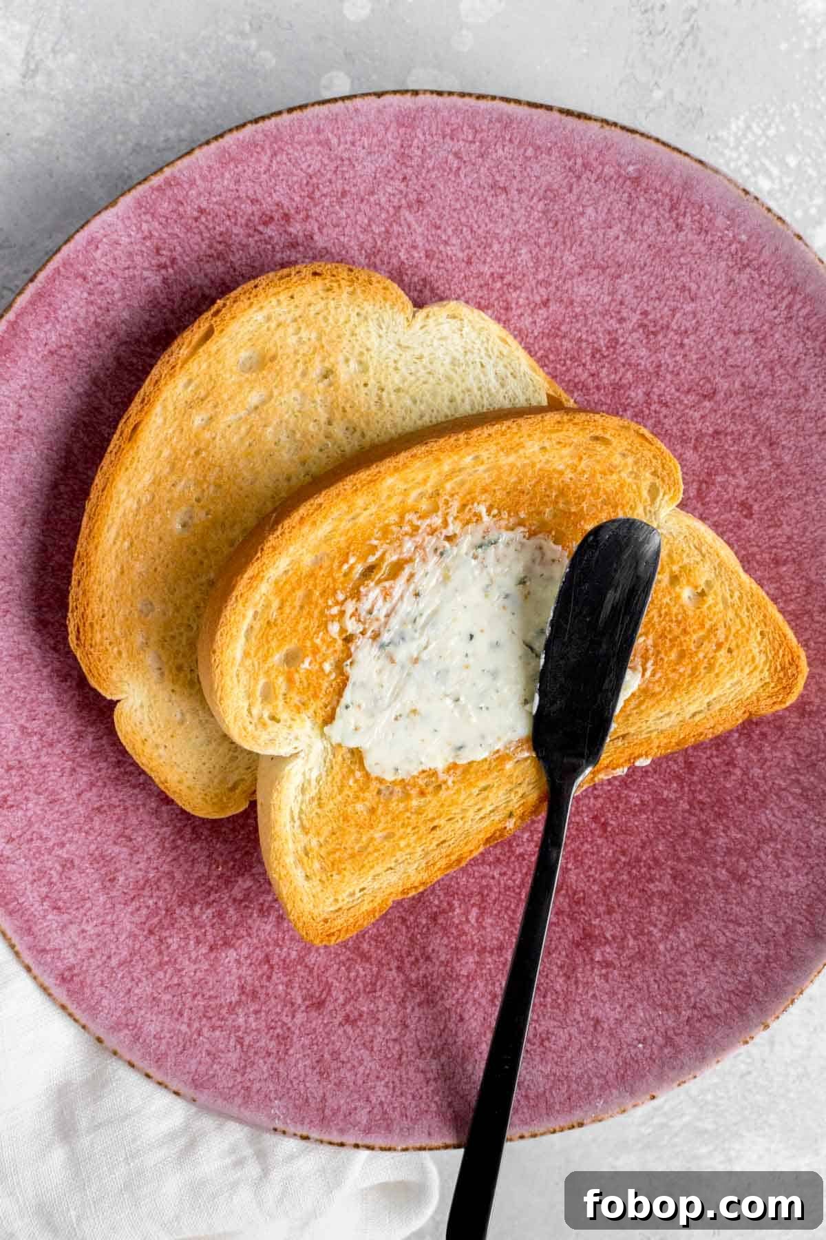 Oven Toasted Bread: How to Toast Slices Perfectly Every Time 2 Close up of buttered toast on a pink plate.
