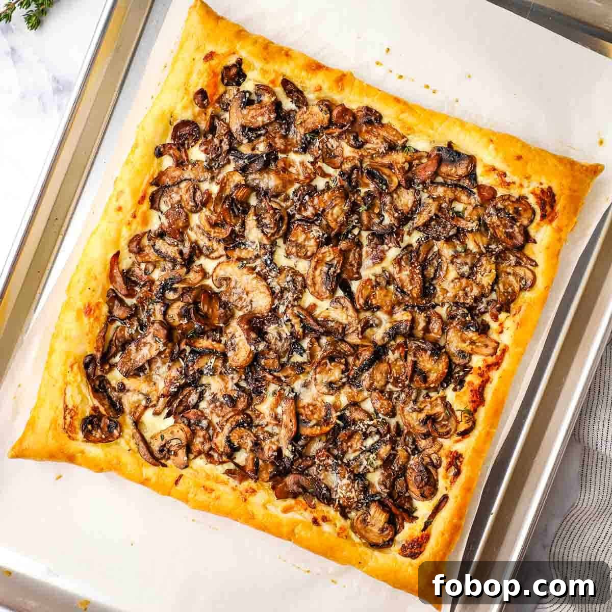 Savory Mushroom Tart with Caramelized Onions and Thyme 6 baked mushroom tart on a parchment lined baking sheet
