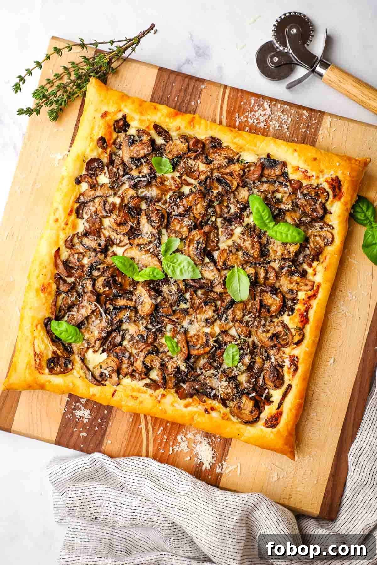 Savory Mushroom Tart with Caramelized Onions and Thyme 5 a whole baked mushroom tart on a cutting board