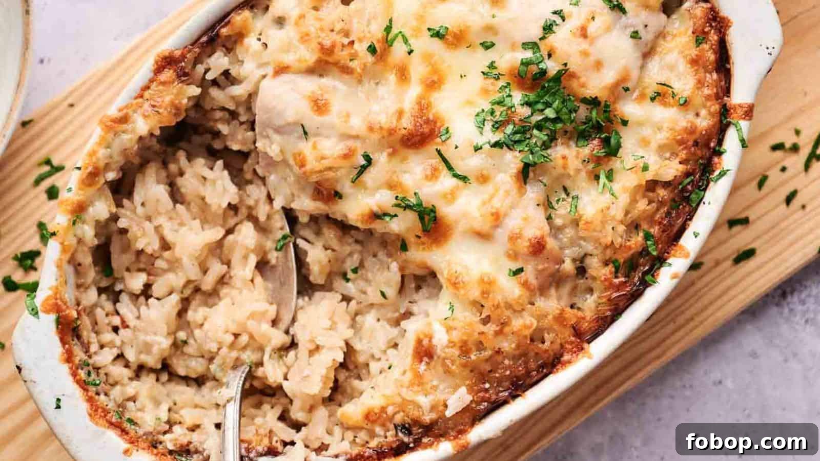 Baked rice casserole with melted cheese on top, garnished with chopped herbs.