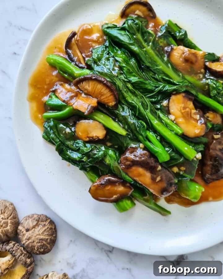 Close up of Chinese broccoli with shiitake mushrooms on top left corner
